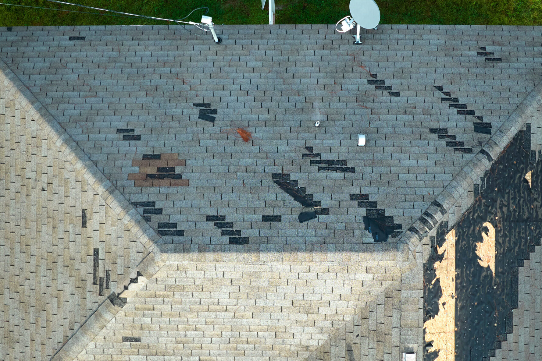 Wind damaged house roof with missing asphalt shingles free roof inspection wind storm wind damage